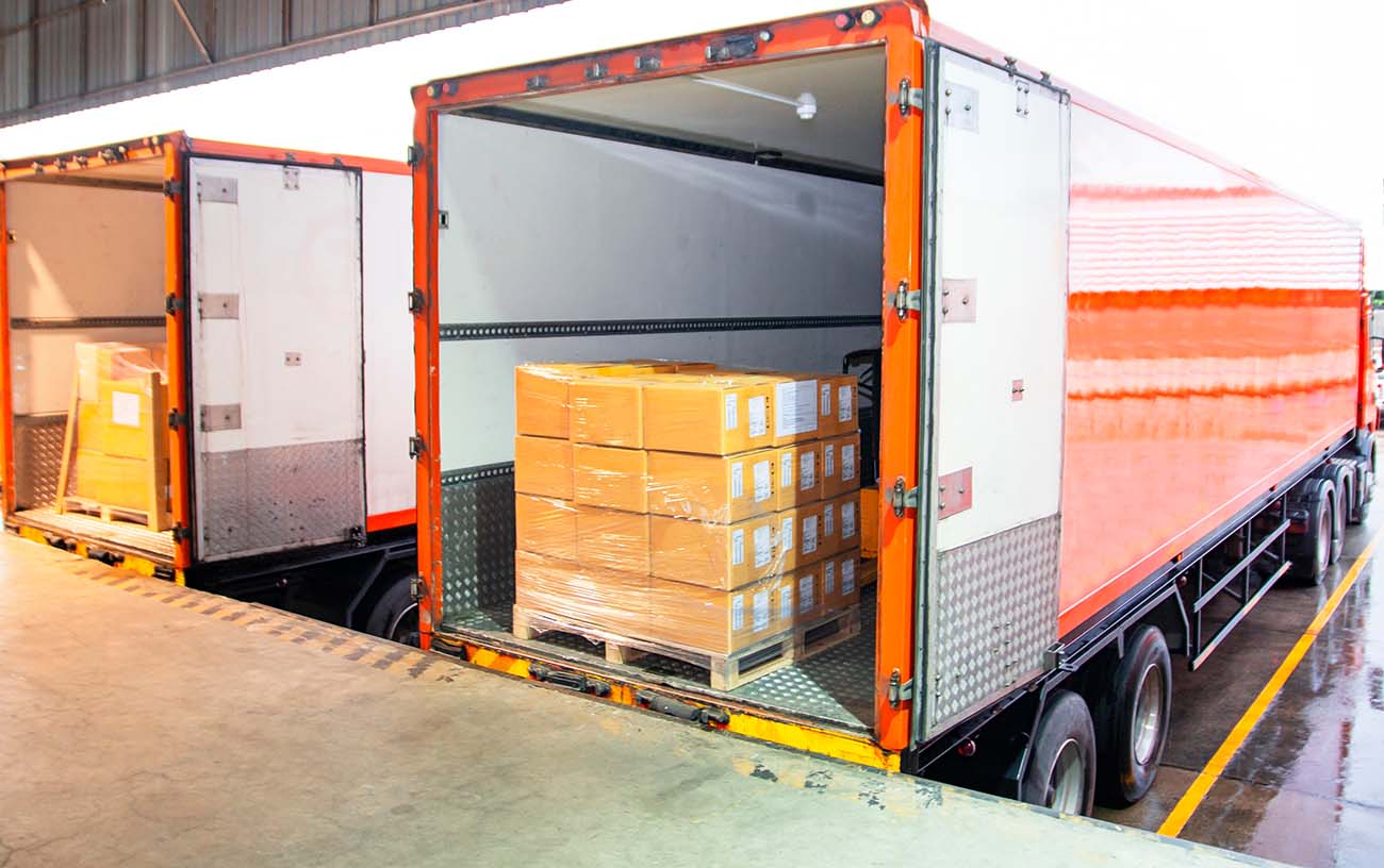 paquetes de cajas apiladas envueltas en plástico en una carga de paletas en un camión